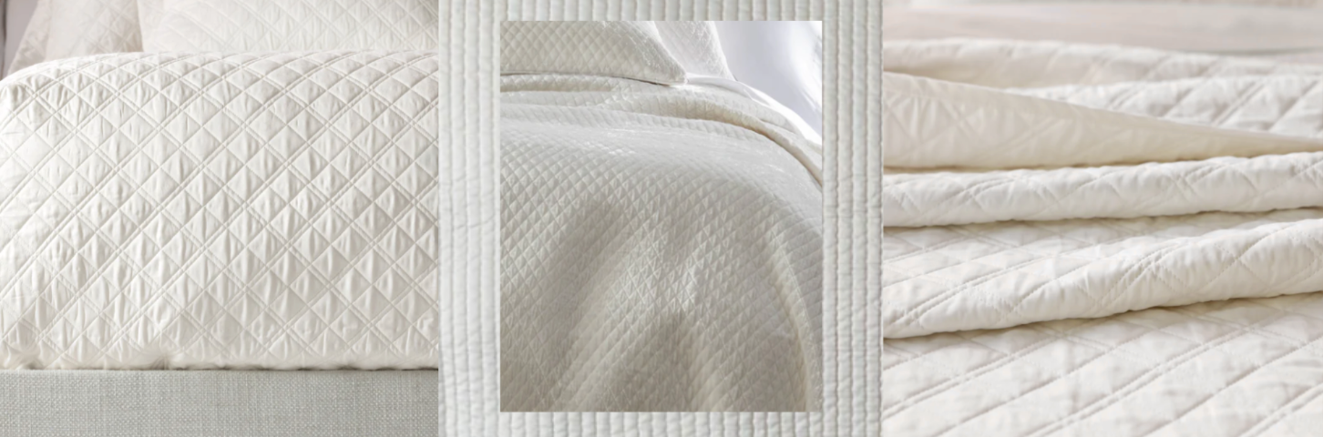 White bed sheets with blush pink double-line embroidery on pillowcases and flat sheet, displayed on a neatly made bed with soft white textured background