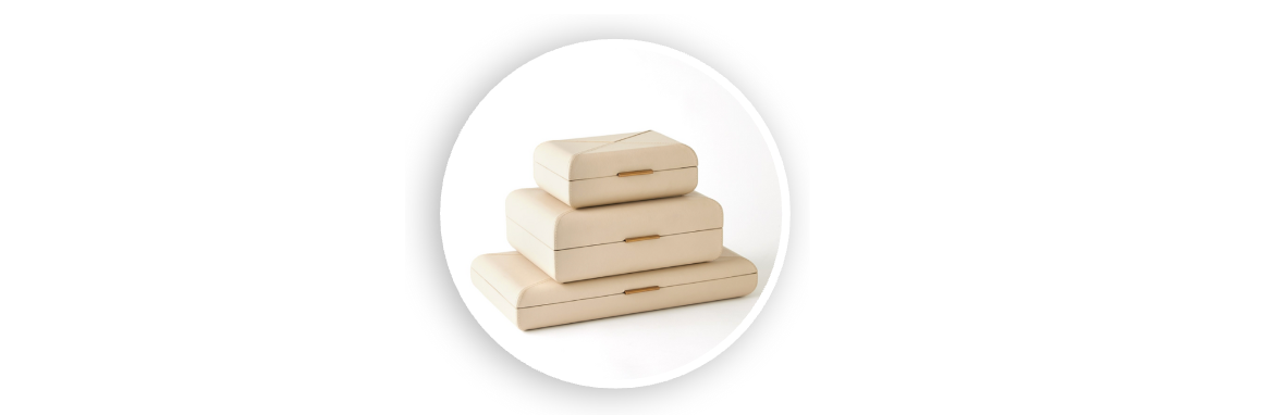 Stack of four decorative neutral-toned books with minimalist covers and subtle cutout handles, arranged on a white background