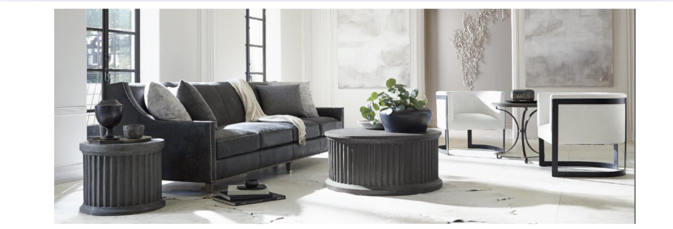 Modern living room featuring a charcoal leather sofa with fluted wood coffee and side tables, styled with neutral decor, black accent furniture, and abstract wall art