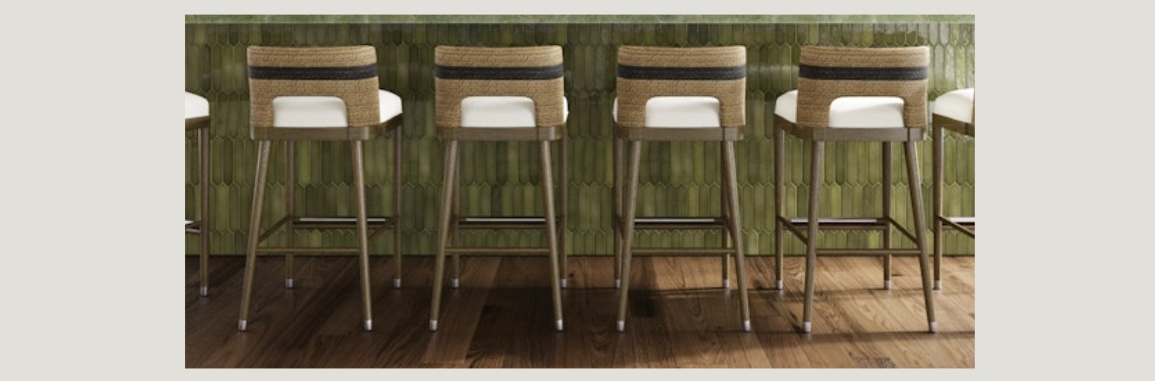 Row of modern barstools with woven backs, white cushions, and wooden legs, lined up at a green tiled bar with warm wood flooring